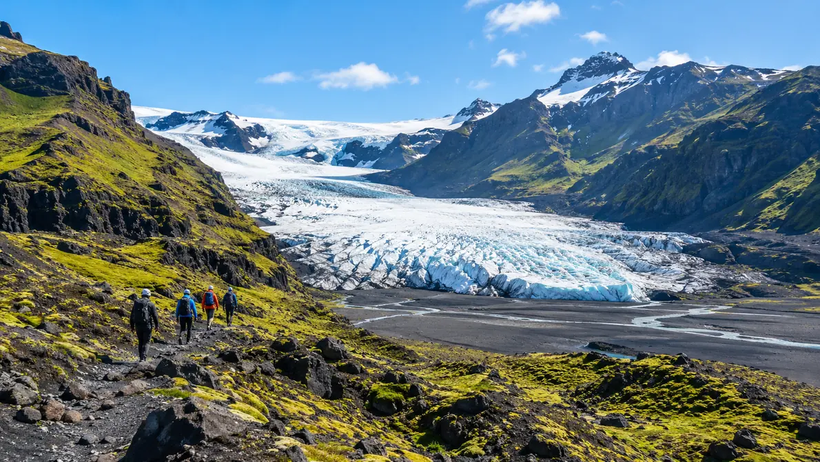 A wide glacier tongue spilling between dark mountains in Vatnajökull National Park